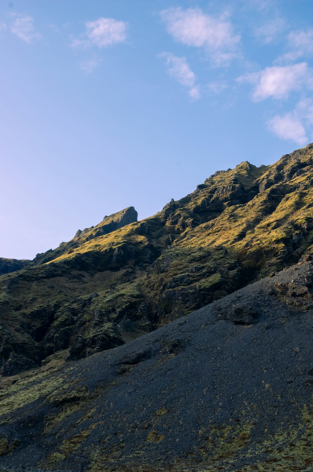 a grassy hill with a blue sky in the background