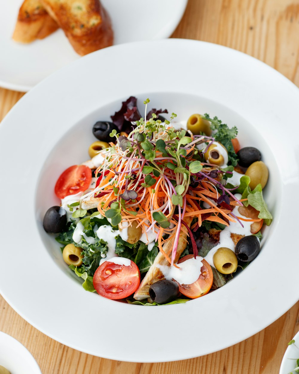 a white bowl filled with a salad on top of a wooden table