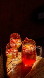 a pitcher of tea and three glasses of tea on a table