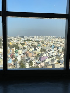 An aerial view of a bustling Kolkata neighborhood with a mix of residential and commercial buildings under a clear sky.