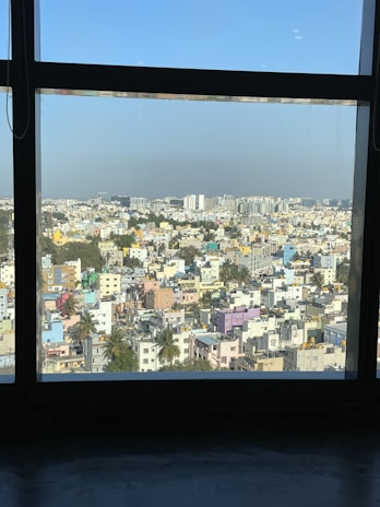 An aerial view of a bustling Kolkata neighborhood with a mix of residential and commercial buildings under a clear sky.