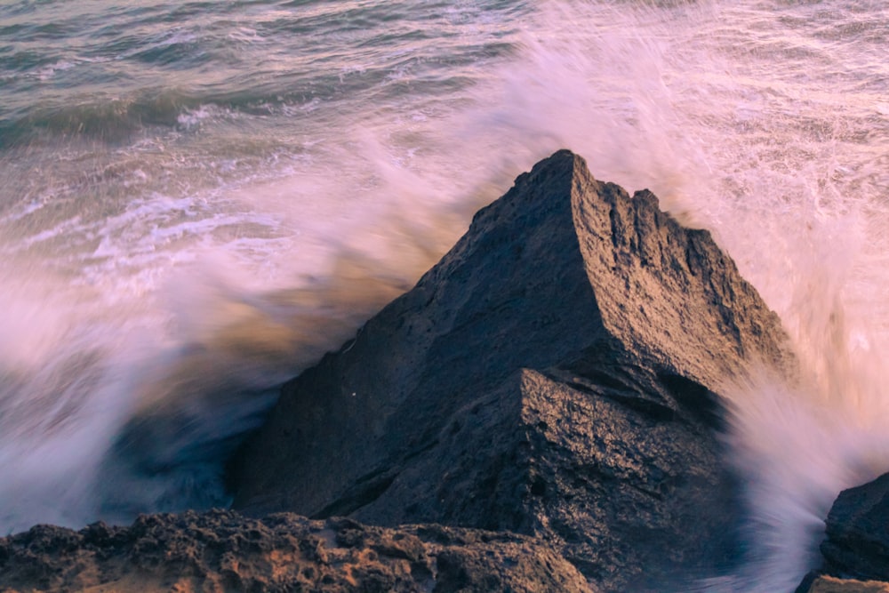 a large rock sticking out of the ocean