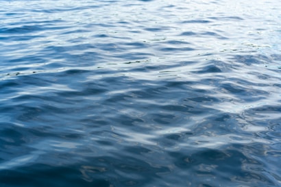 Calm water surface with gentle ripples creating a soothing and serene effect. The light plays on the surface, creating a subtle shimmer.