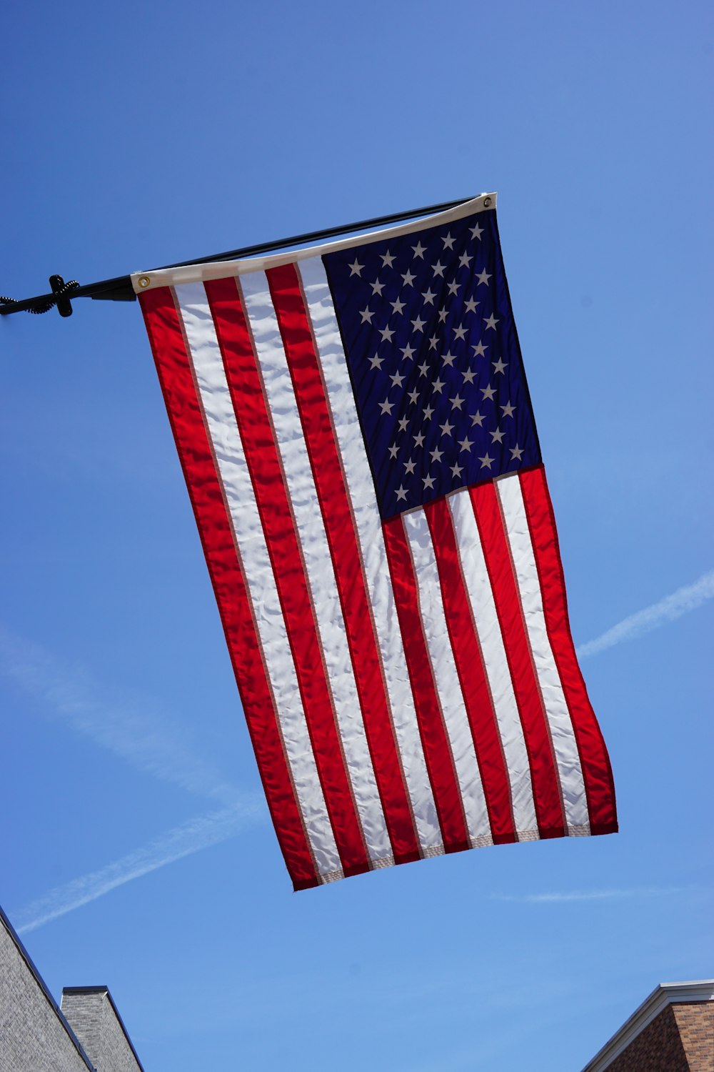 a large american flag hanging from a wire