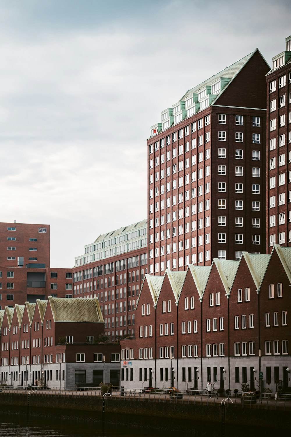 a row of red brick buildings next to a body of water