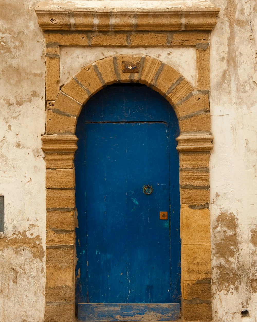 a blue door with a brick arch above it