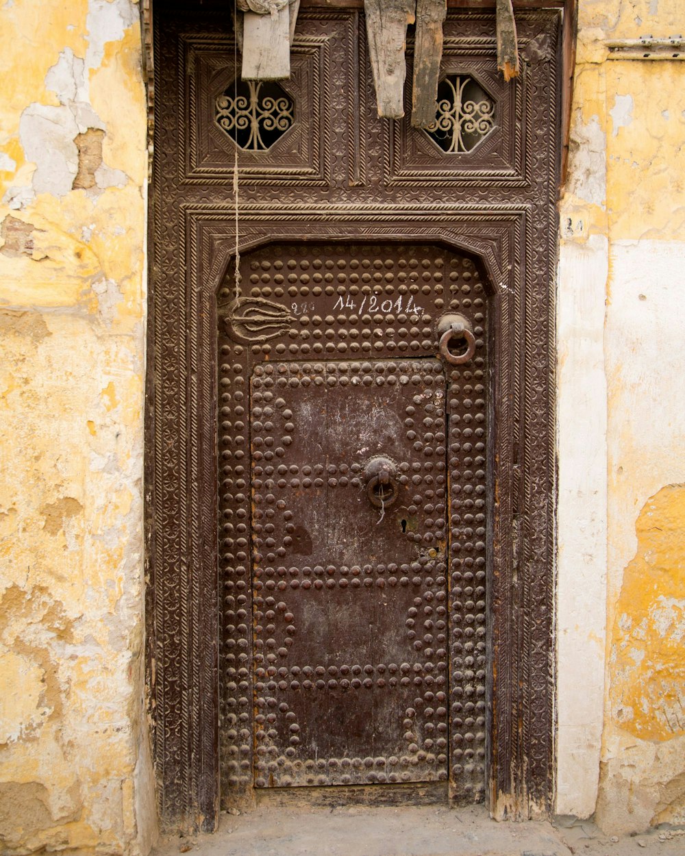 una puerta vieja con una manija de madera en una pared