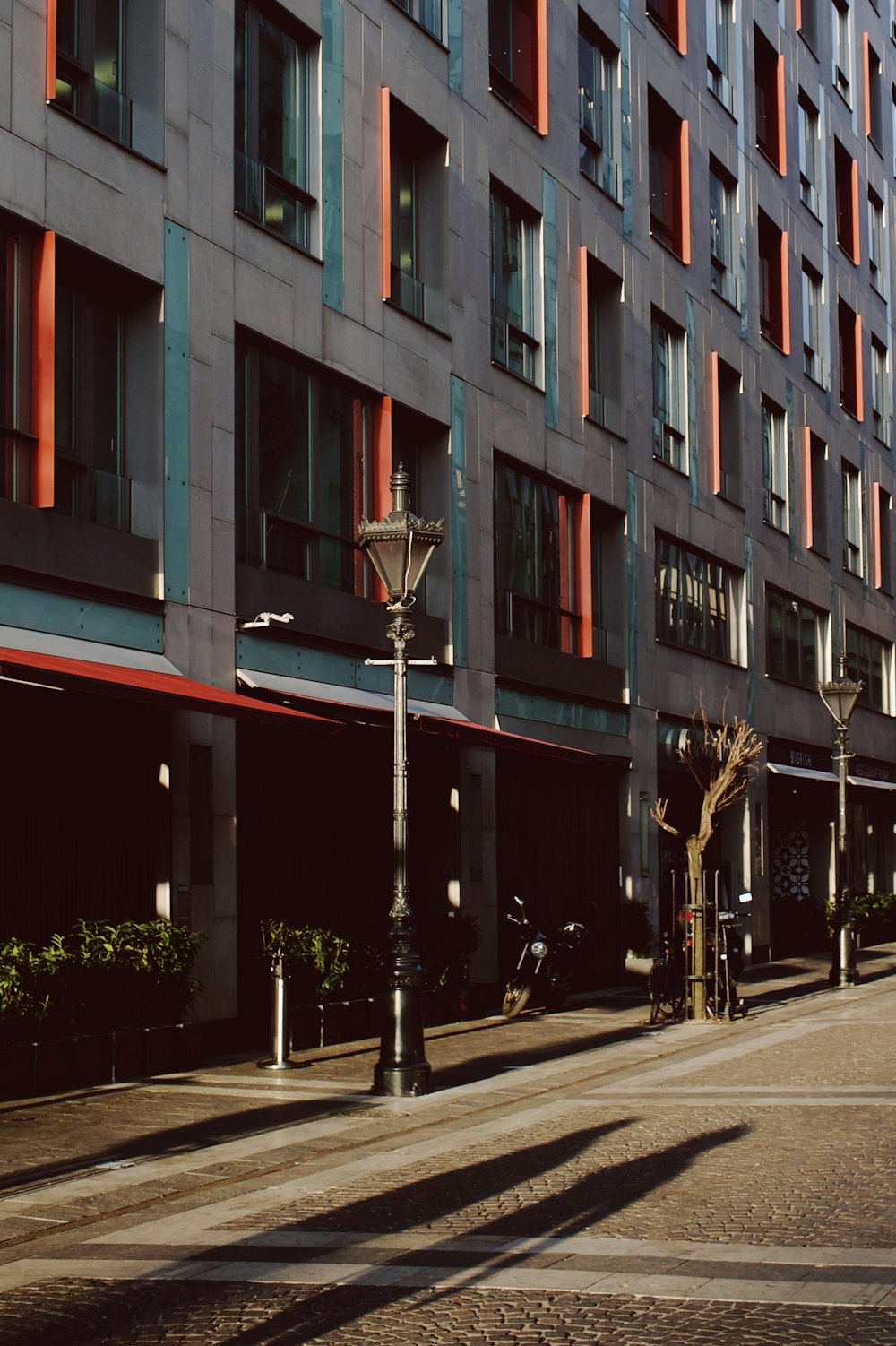 a tall building with many windows next to a street