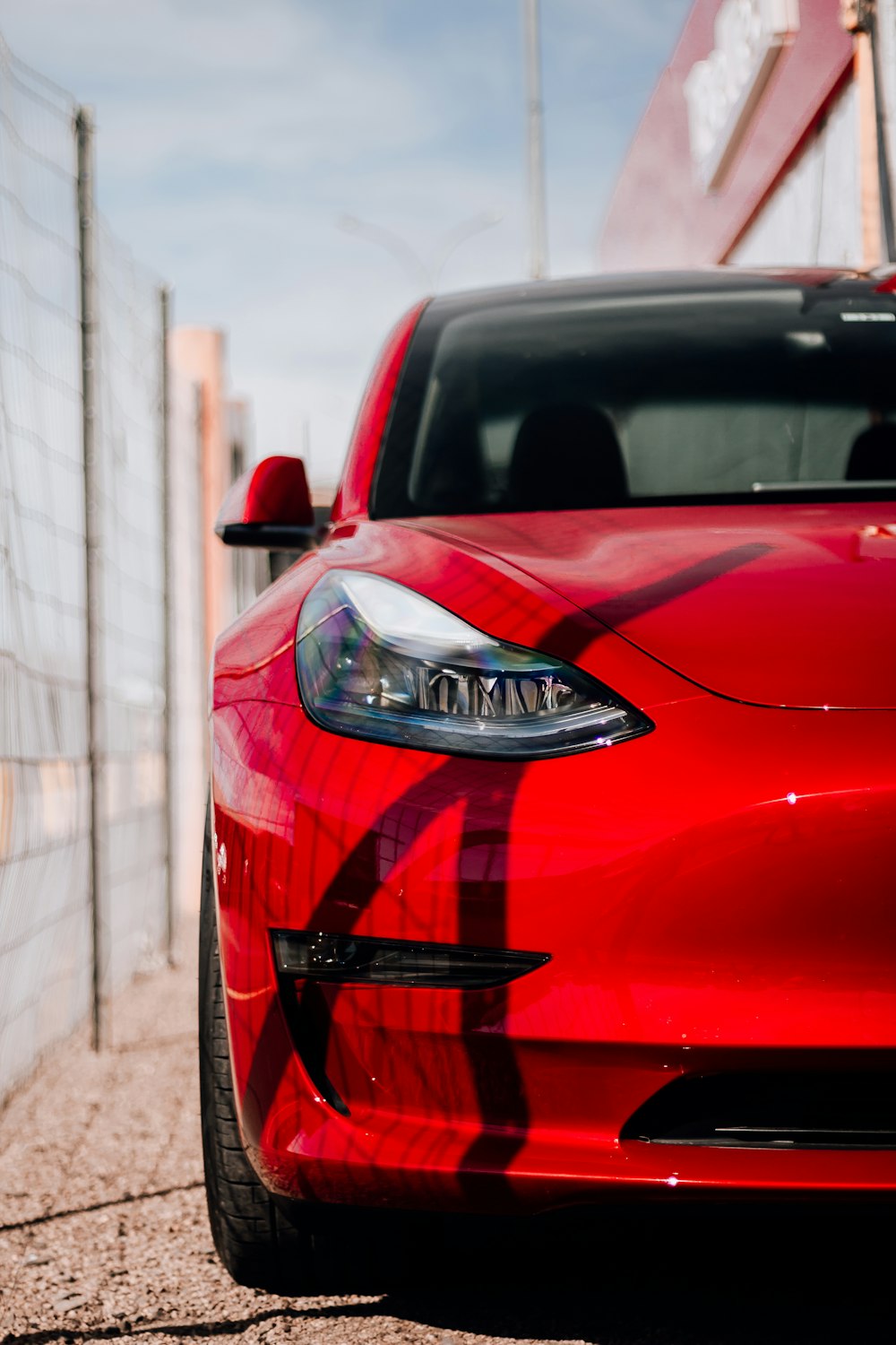 a red sports car parked in front of a fence
