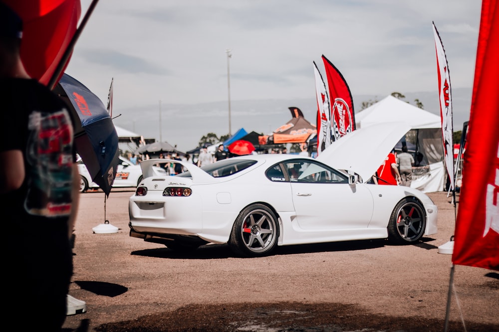 a white sports car parked in a parking lot