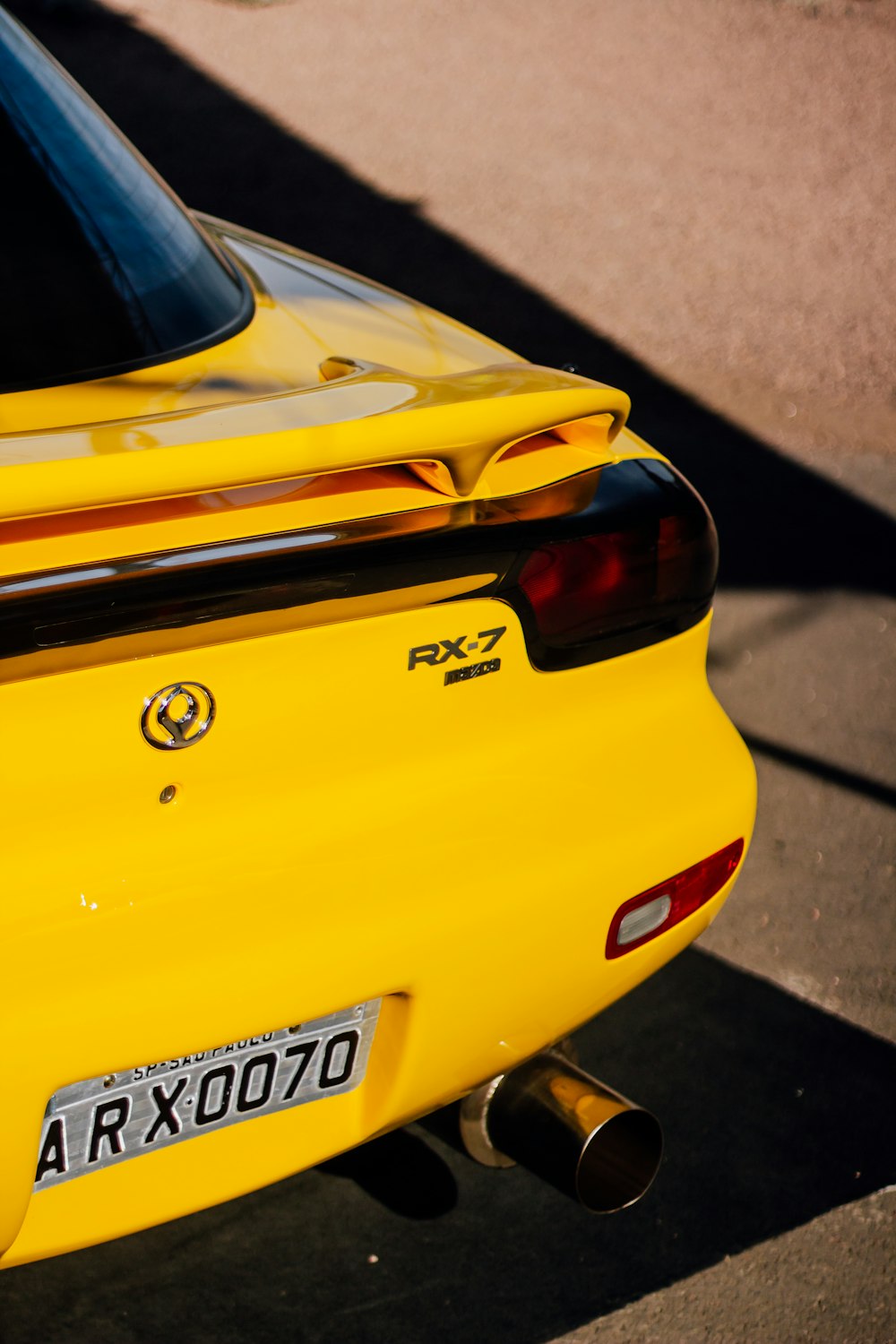 a close up of the rear end of a yellow sports car