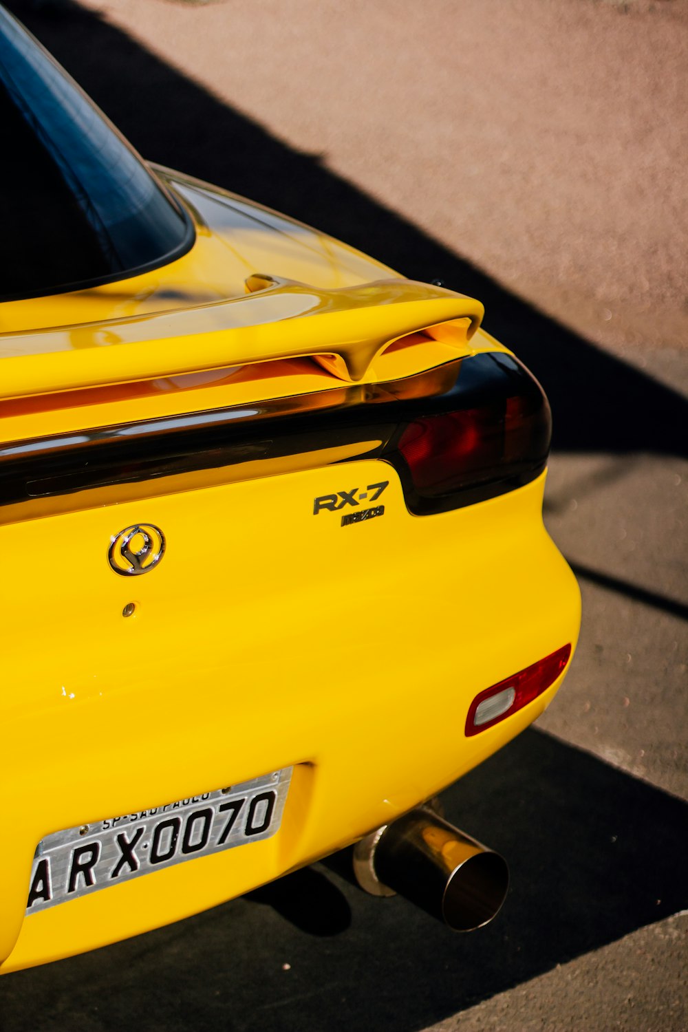 um close up da extremidade traseira de um carro esportivo amarelo