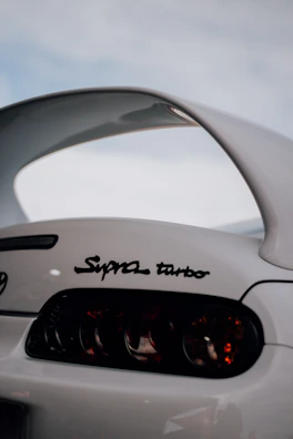 Dynamic shot of a Toyota Supra highlighting its aggressive rear wing and diffuser at dusk.