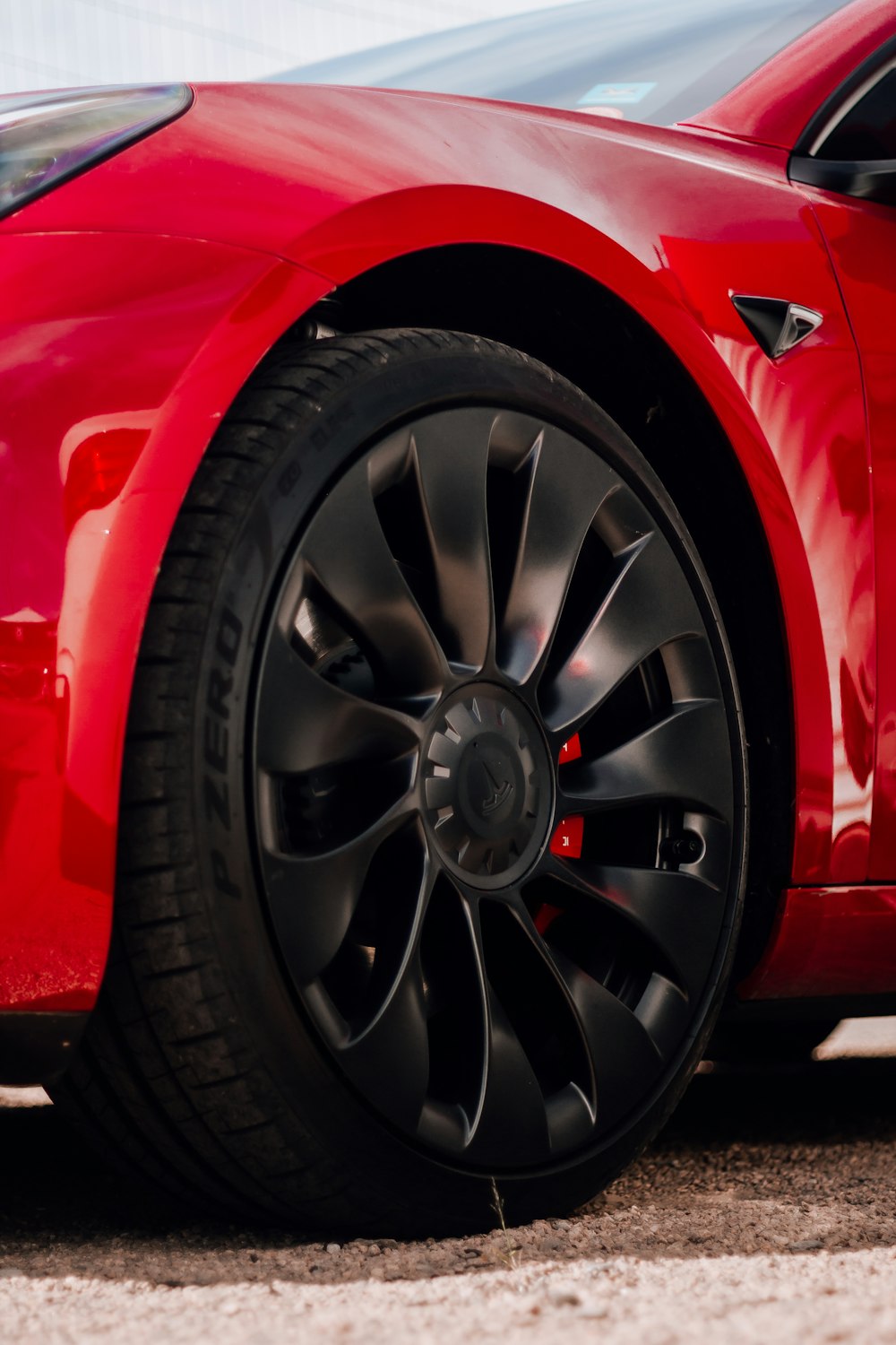 a close up of a red car with black spokes