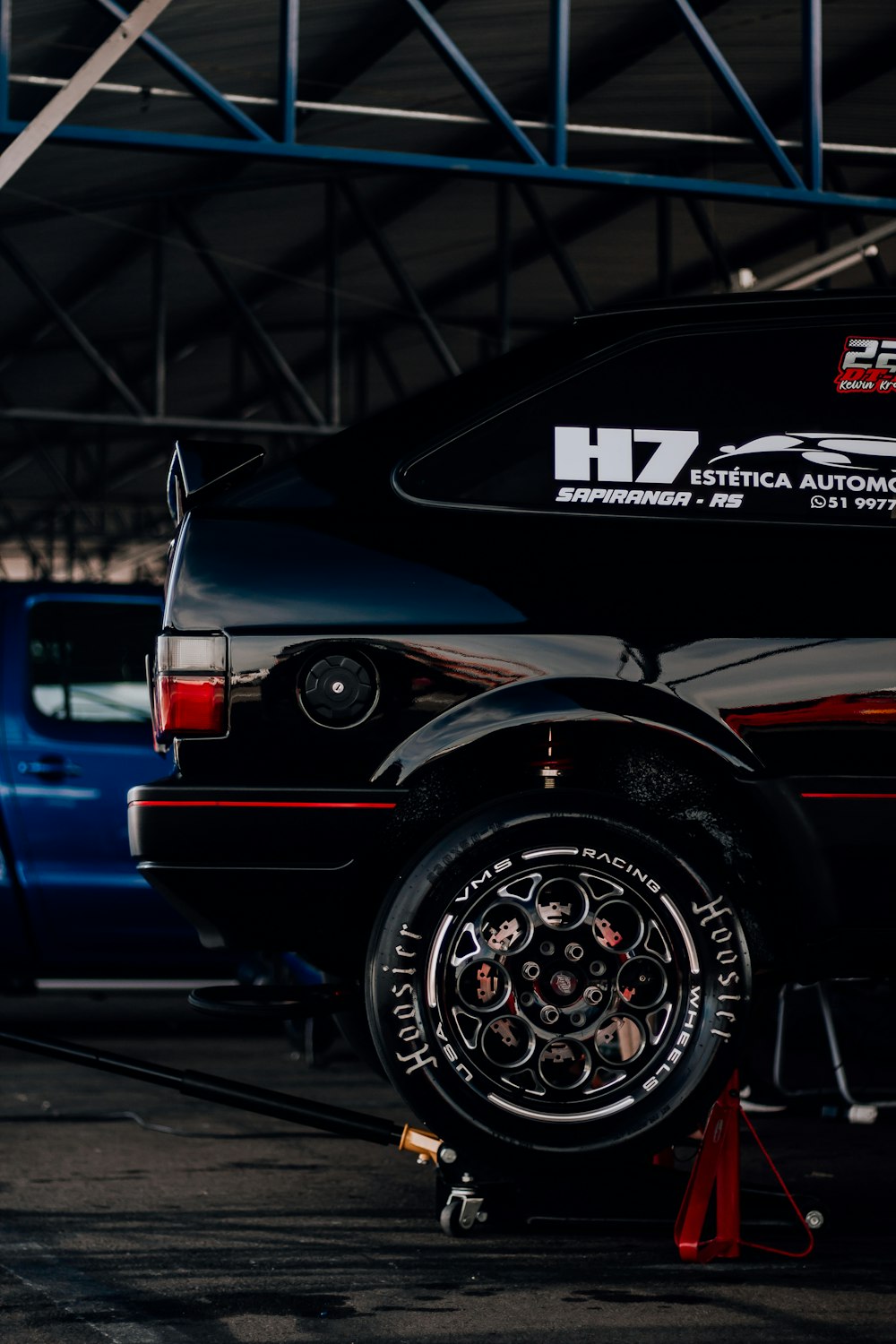 a black truck parked in a garage next to a blue truck