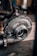 A close-up of a metallic turbocharger, showcasing intricate engineering with bolts and flanges. The machinery appears sturdy and robust, highlighted by a background of blurred mechanical components.