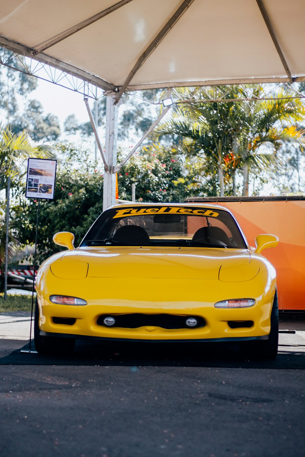 a yellow sports car parked under a tent