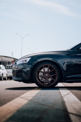 A stylish car parked with a focus on its wheels.