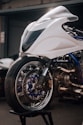 a white motorcycle parked in front of a garage