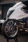 a white motorcycle parked in front of a garage