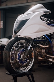 a white motorcycle parked in front of a garage