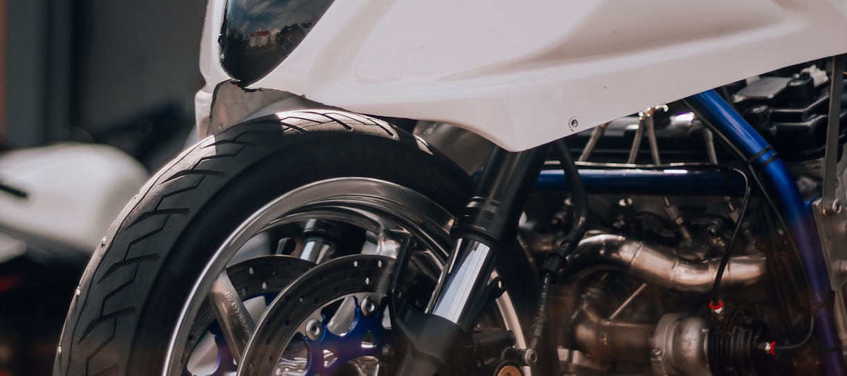 a white motorcycle parked in front of a garage