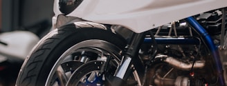 a white motorcycle parked in front of a garage