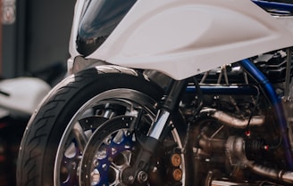 a white motorcycle parked in front of a garage