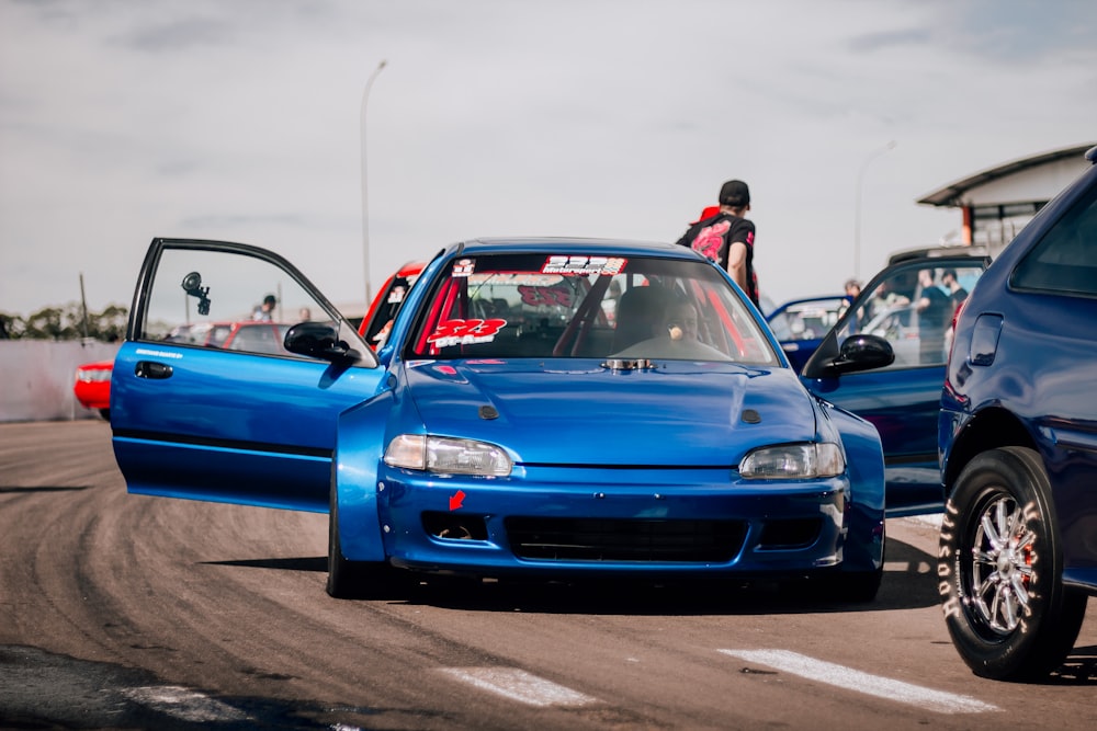 a blue car driving down a race track