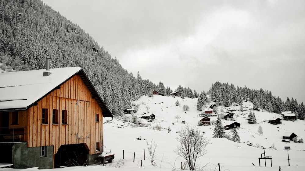 a snow covered mountain with a wooden cabin in the foreground