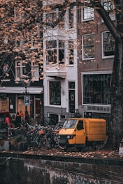 A vibrant street scene showing a car, a motorcycle, and an electric bike parked side by side.