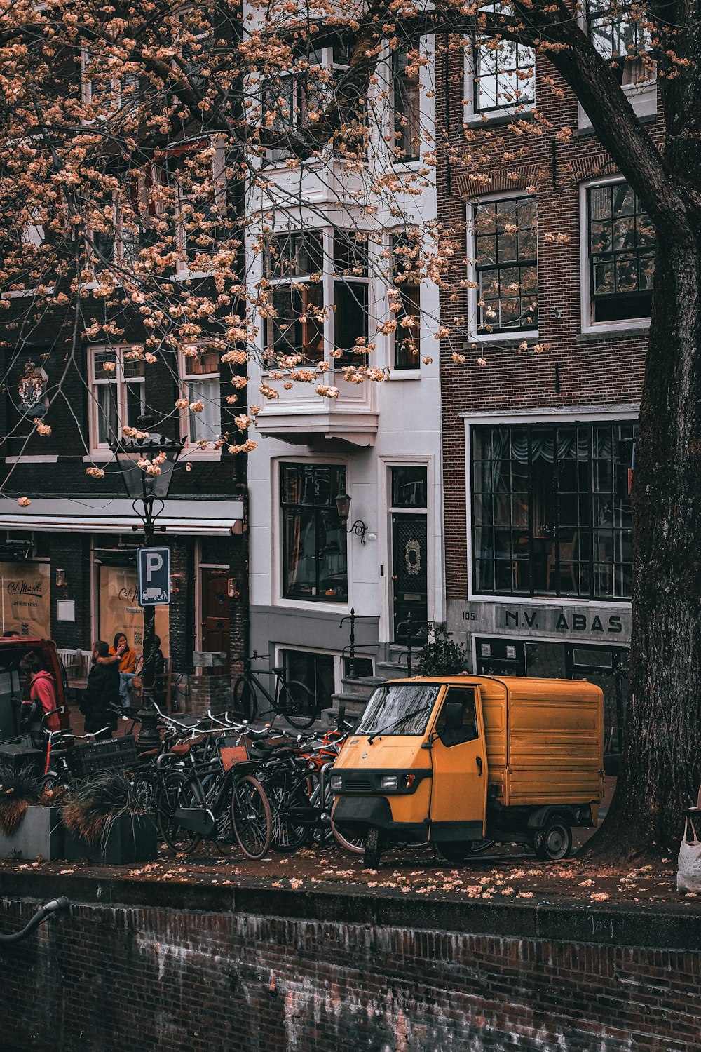 a yellow truck parked in front of a tall building