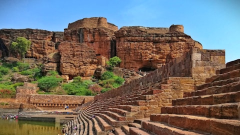 a large stone structure sitting on top of a lush green hillside