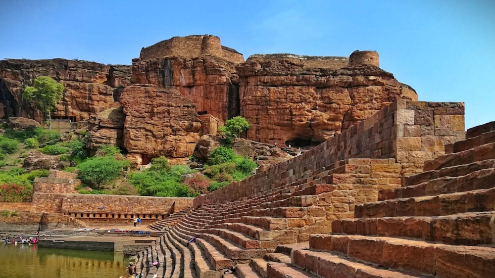 a large stone structure sitting on top of a lush green hillside