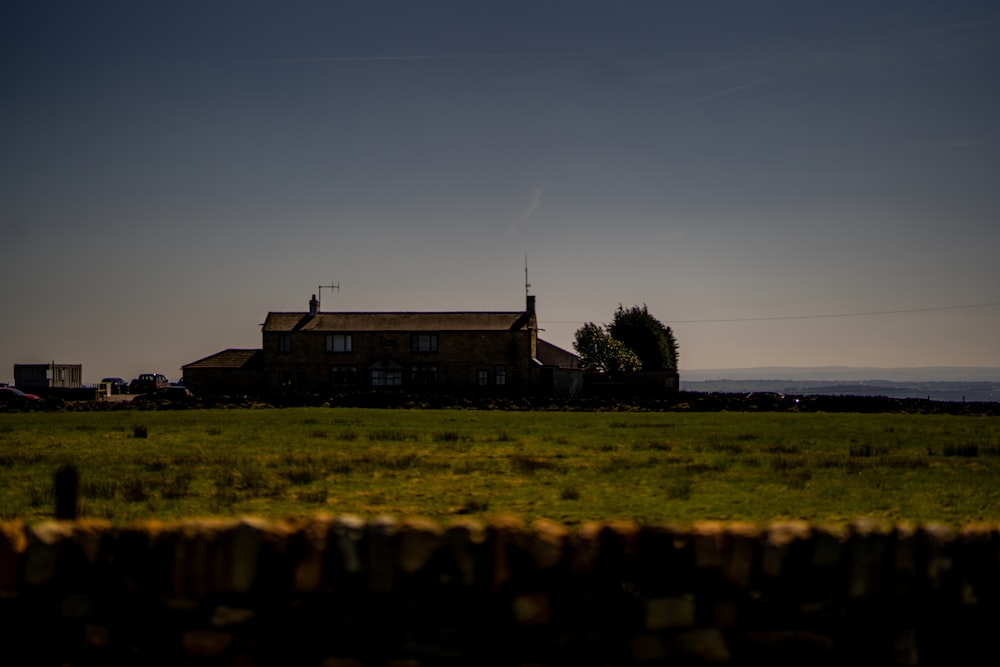 a house in a field with a fence in front of it