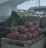 Sunlit crates filled with ripe, juicy heirloom tomatoes at a local farm market.