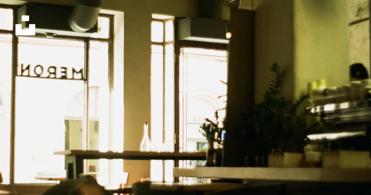 A restaurant with tables and chairs in front of a window photo – Free ...