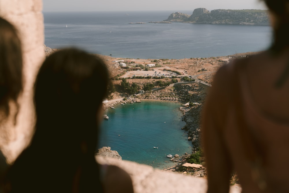 a couple of people standing next to each other near a body of water