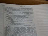 A close-up view of an open book showing text from the Bible, specifically Jeremiah 3:22, with printed lines and numbers visible on a slightly curved page.