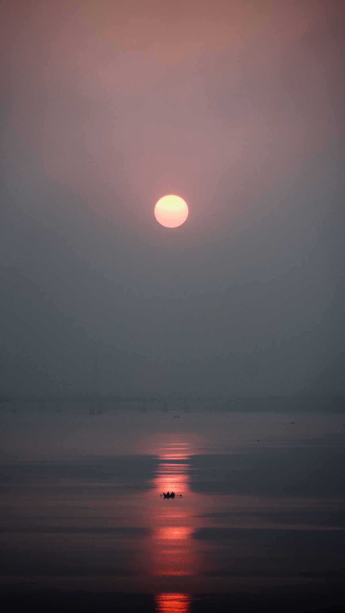A fishing boat on a wide river at sunset near Bharuch, Gujarat (representative image)