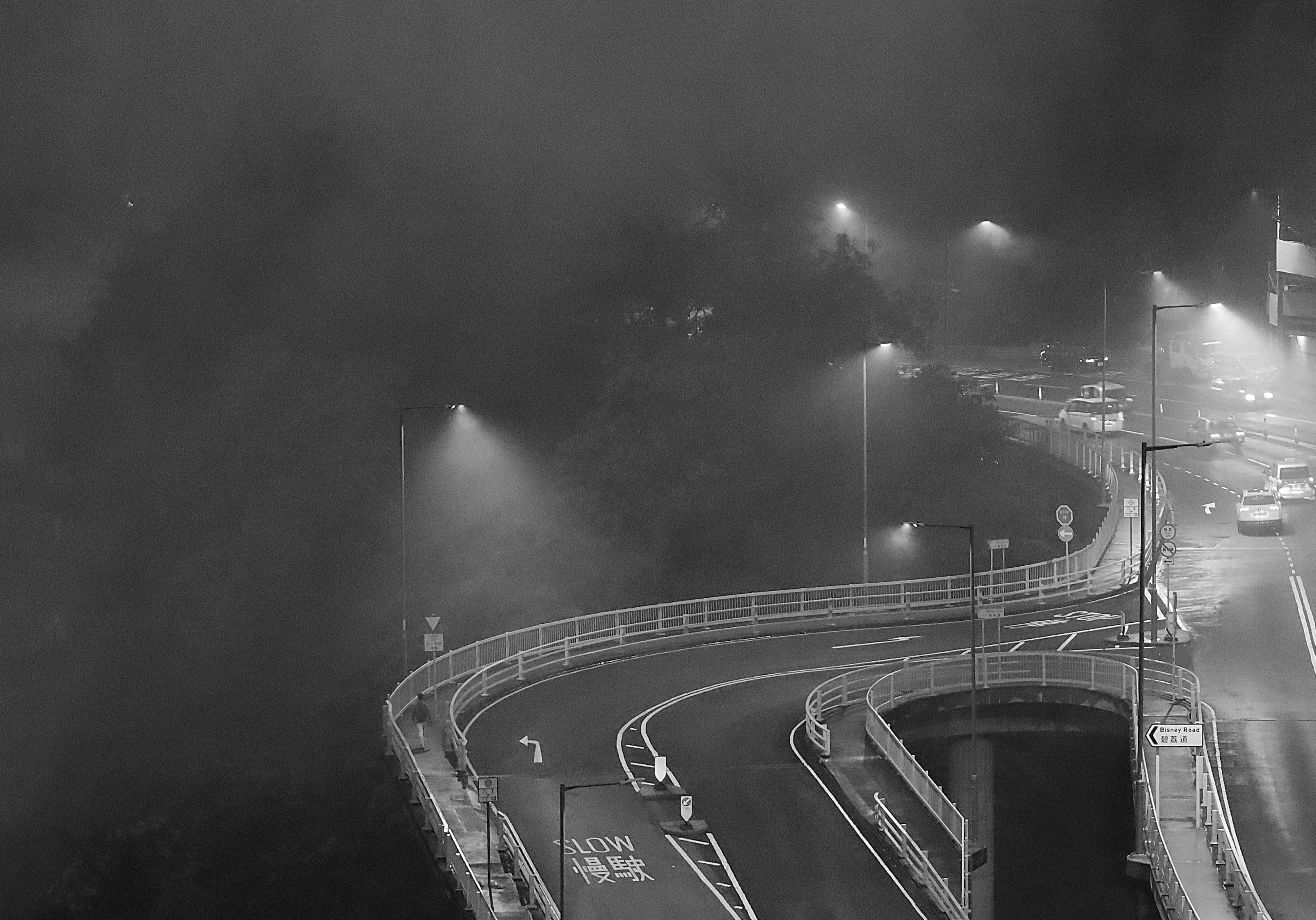 uma foto em preto e branco de uma rodovia enevoada