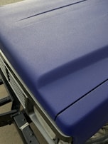 Detail of a hand applying clear coat to a freshly painted car hood for a durable finish.