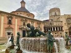 a fountain with a statue of a boy sitting on top of it