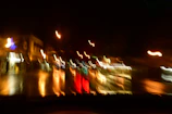 A dynamic shot of city lights reflecting on wet pavement, glowing in blues and golds.