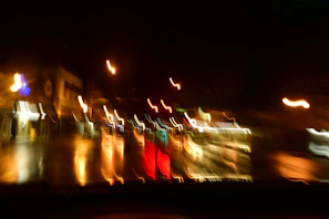 A dynamic shot of city lights reflecting on wet pavement, glowing in blues and golds.