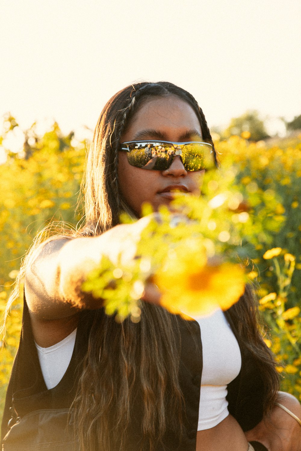 Una mujer con gafas de sol de pie en un campo de flores