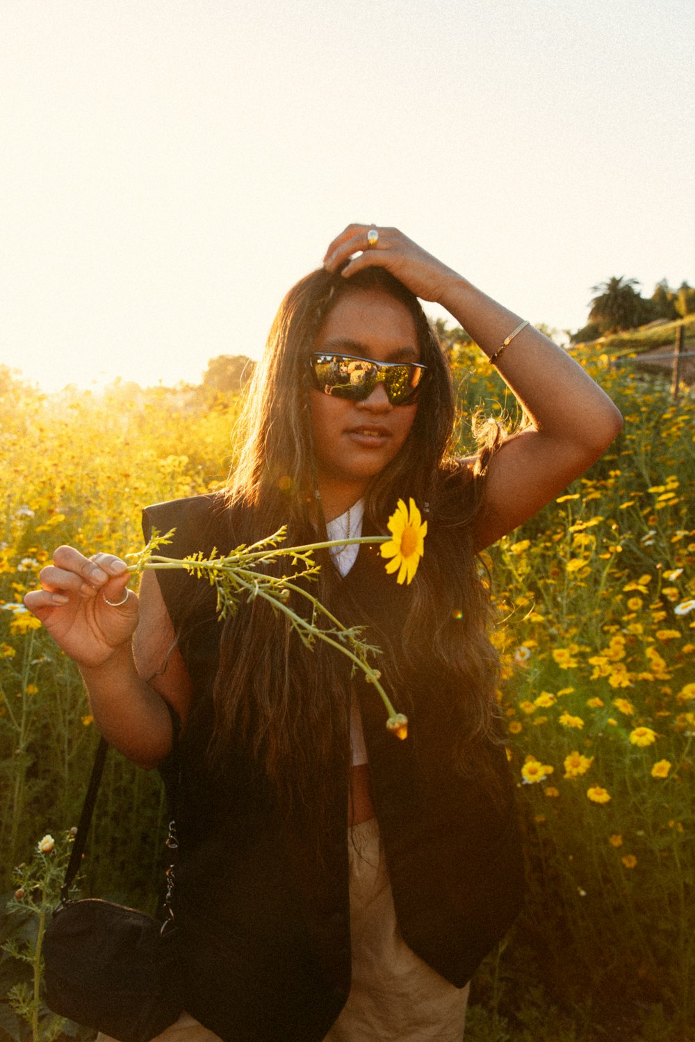 a woman wearing sunglasses and a flower in her hair