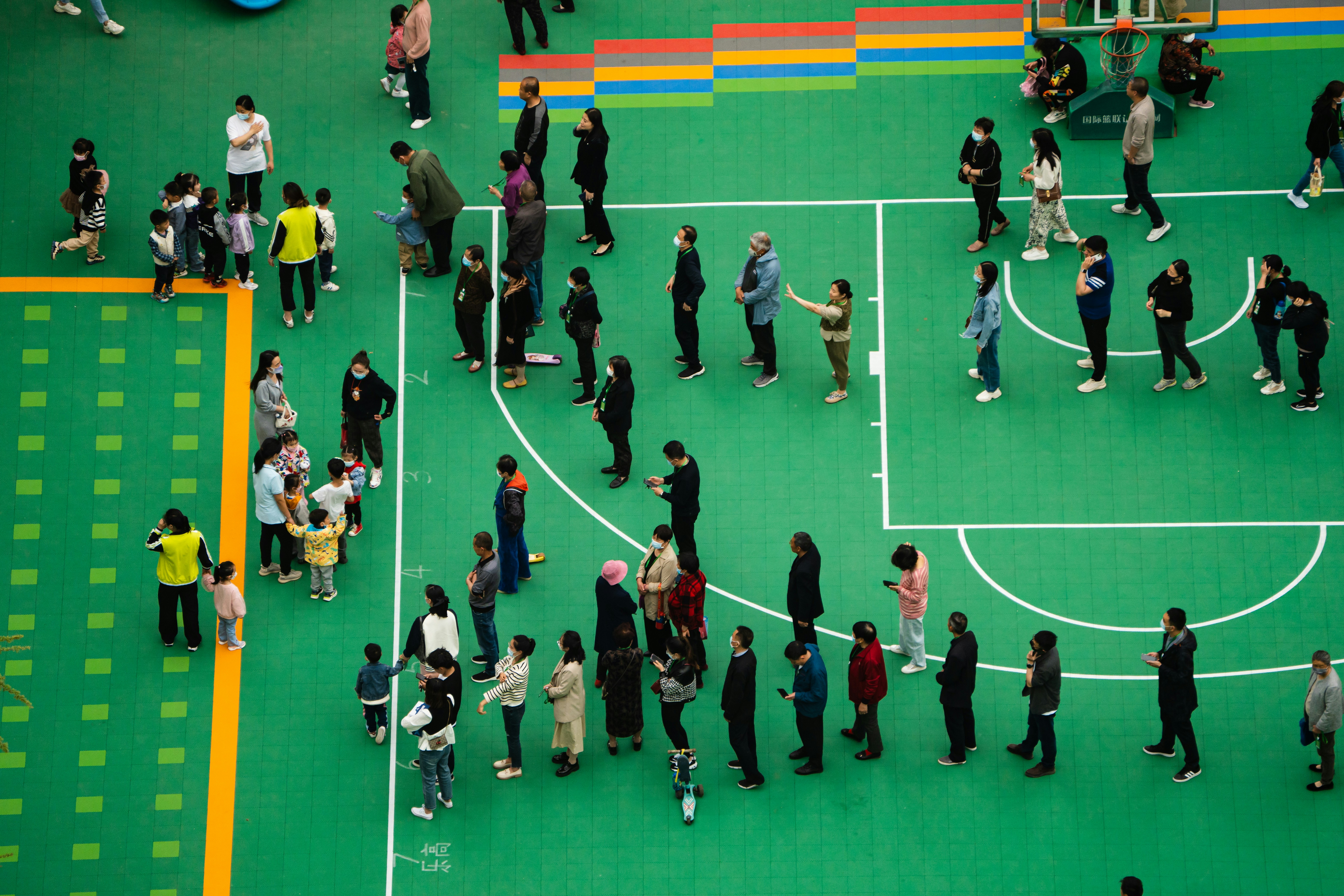 a group of people standing on a green basketball court