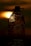 A silhouette of a plastic water bottle is prominently displayed against a rich, warm sunset background. The sun's glow creates a halo effect around the bottle, highlighting its textured surface and water droplets.