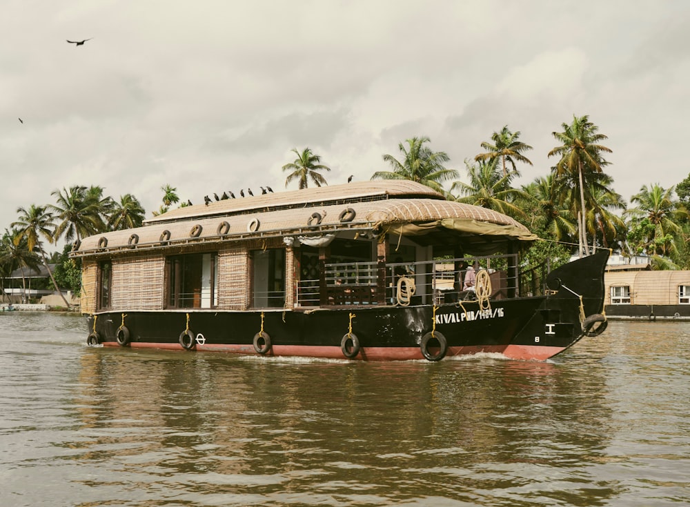 a house boat with a thatched roof on the water